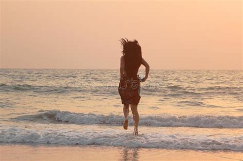 girl runs along the beach at sunset stock image image of ocean wave