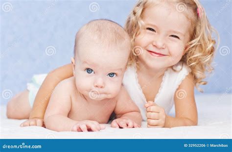 happy sister hugging baby brother stock photo image