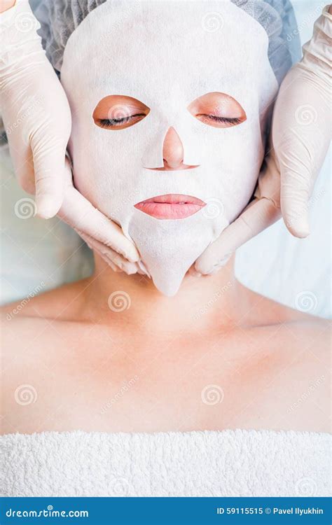 woman relaxing  spa salon applying white face mask stock image