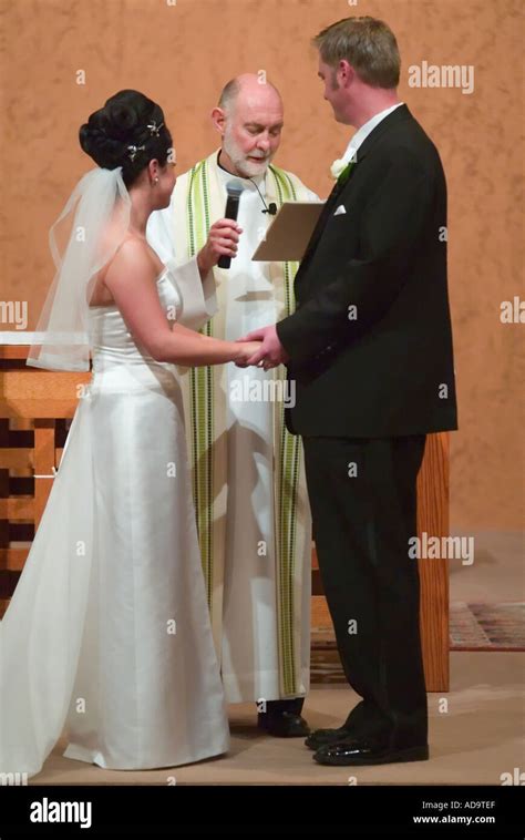 a priest reads the marriage vows at a formal catholic wedding in irvine