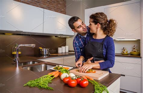 couple in kitchen hugging and cook high quality people images