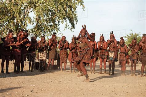 women from himba people in traditional clothes and haircuts are