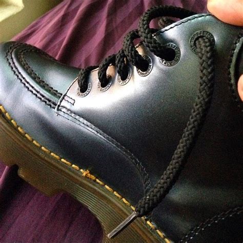 dark grey metallic dr martens left boot   tears   top  shown   laces