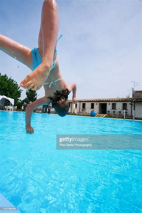 happy girl diving into swimming pool photo getty images