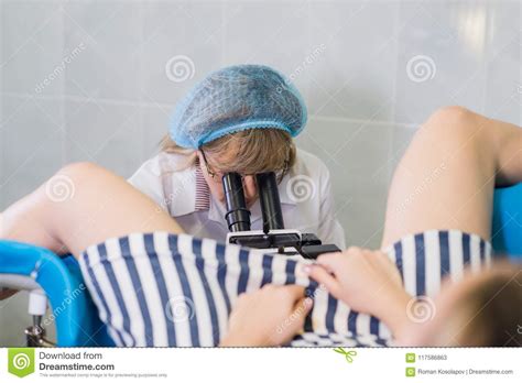 professional gynecologist examining her female patient on