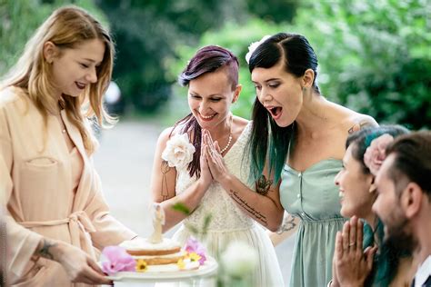 lesbian couple receiving their wedding cake by stocksy contributor