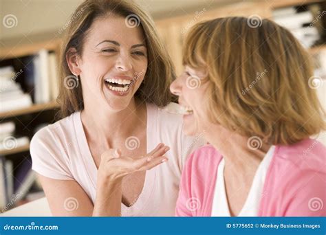 twee vrouwen die  woonkamer het spreken en lach zitten stock foto image  generatie