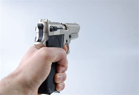 person holding black gold semi automatic pistol hand weapon gun