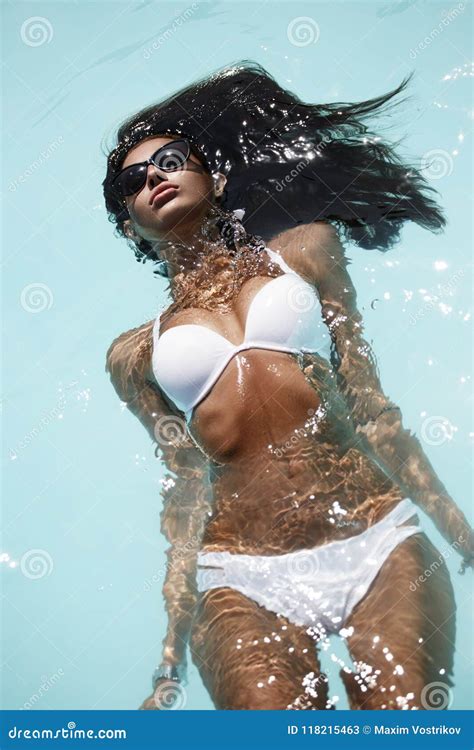 La Mujer Morena Atractiva En El Bikini Blanco En El Cuerpo Bronceado Y