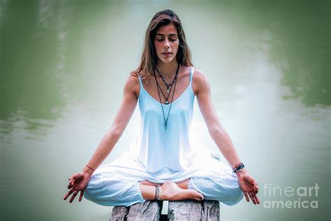 woman meditating by a lake photograph by microgen images science photo