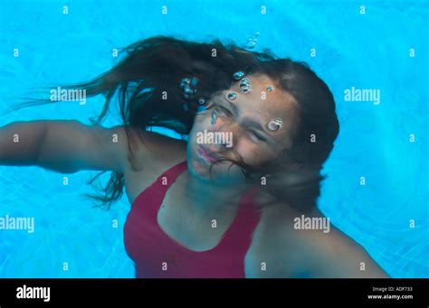 Teenage Girl Wearing Red Bathing Suit Floats In Swimming Pool Just