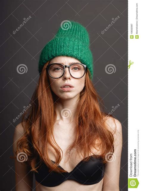 Fashion Redhead Girl In Knitted Hat And Galsses On Grey