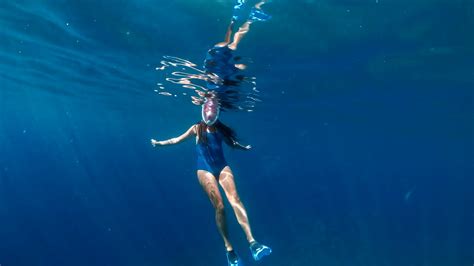 fashionable and athletic girl diver alone in the depths of the ocean