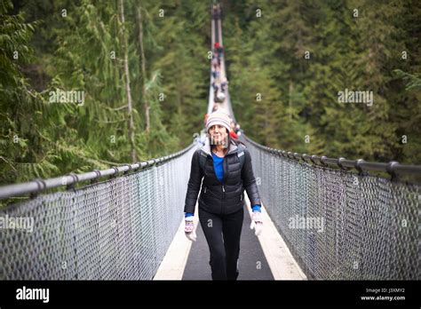 woman walking across capilano suspension bridge vancouver canada
