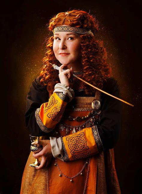 A Woman Dressed In Medieval Clothing Holding A Stick And Looking At The