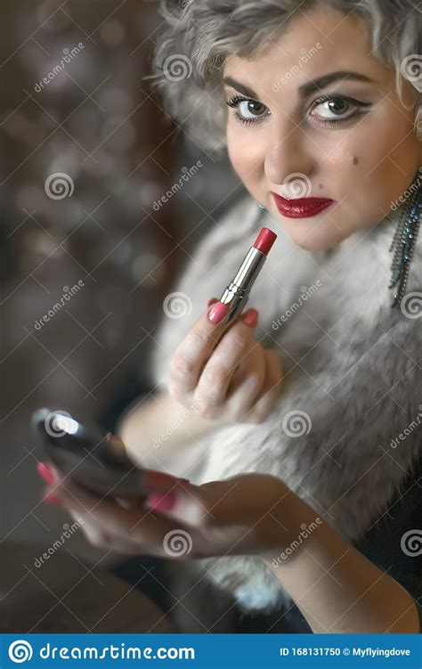 close up portrait of pretty woman correcting makeup