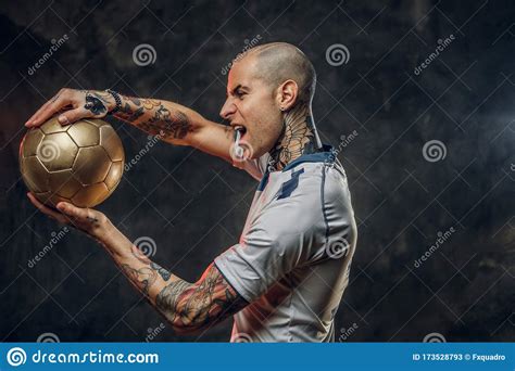 rebellous tattooed bald fashionable male soccer player posing   studio   photoshoot