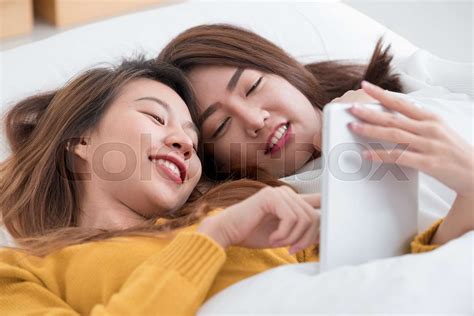 Asia Lesbian Lgbt Couple Lying On Bed Using Tablet Together In Bedroom