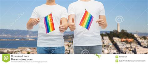 male couple with gay pride flags showing thumbs up stock image image