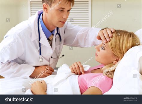 photo of male doctor touching patient womans head in