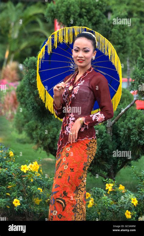 A Young Malaysian Woman Dressed In Traditional Costume With Colorful