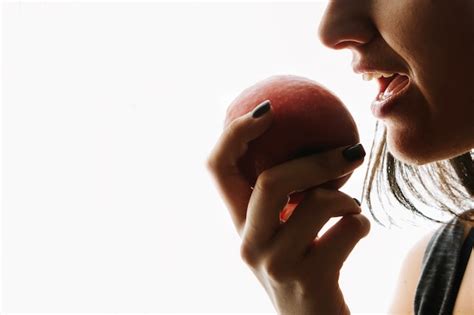 vrouw die rode appel eet premium foto