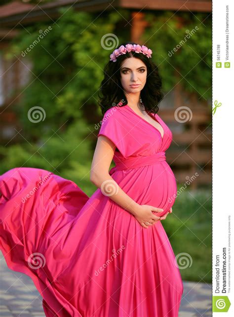 beautiful pregnant woman touching her belly wearing in