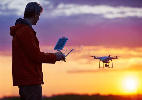 man operating  flying drone  sunset stock image image  discovery piloting