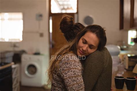 Lesbian Couple Hugging In Kitchen At Home — Lock Down Closeness