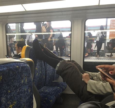 angry commuter takes photo of man taking up six seats on a packed train