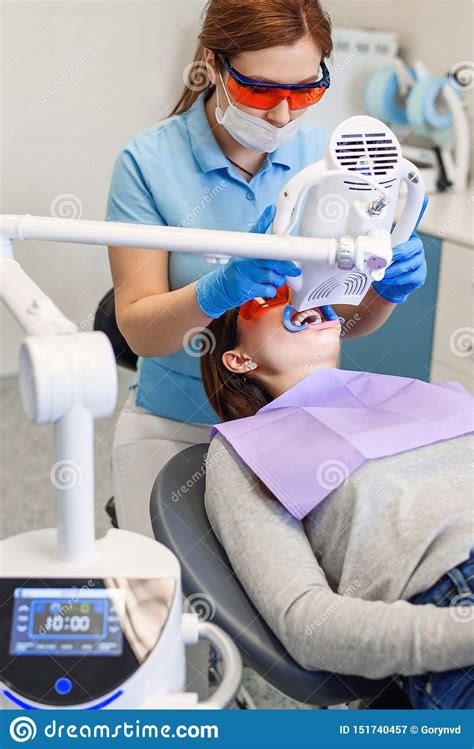 teeth whitening procedure for pretty happy female patient