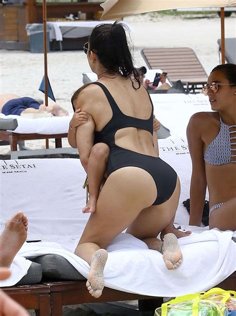 kourtney kardashian in back swimsuit at a beach in miami