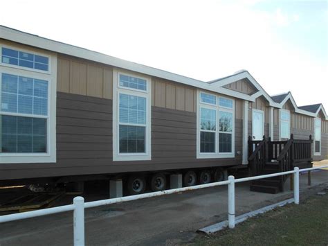 mobile home  parked   side   road  front   white fence