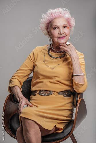 Smiling Elderly Woman Sitting On Chair Stockfotos Und Lizenzfreie