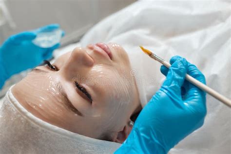 beautiful brunette woman enjoying applying cosmetic mask  closed