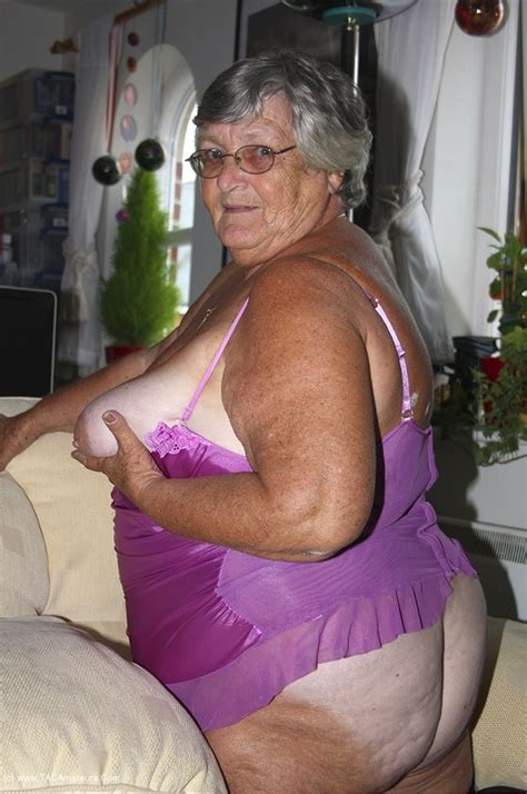 gorgeous granny shows her nasty pussy as she spreads wide on a white couch wearing her shiny