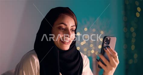 سيدة عربية تقوم بجلسة تصوير في المنزل ، إجراء مكالمة فيديو بإستخدام