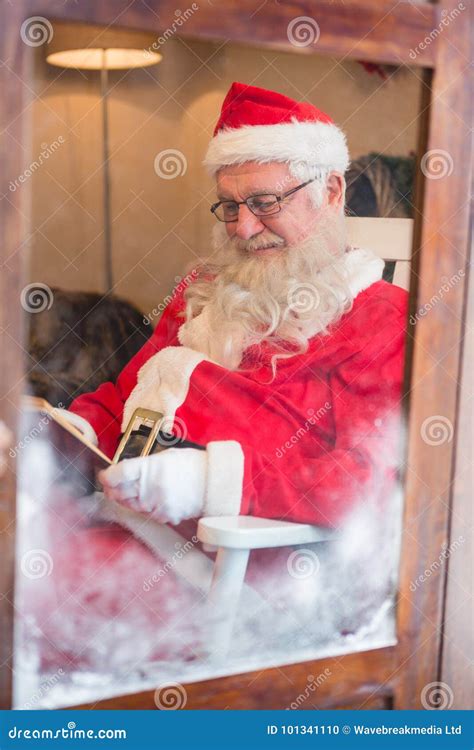 smiling santa claus reading   christmas time stock photo