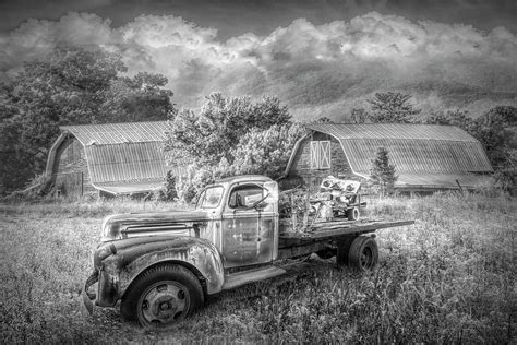 rusty old truck and barns in black and white photograph by debra and
