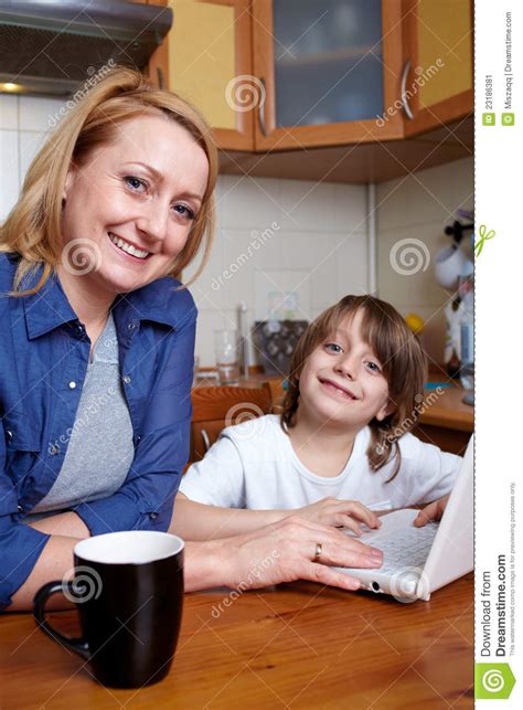 mother and son sits in kitchen and use laptop stock image image 23186381