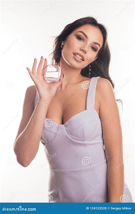 Portrait Of A Sensual Young Brunette Woman With A Perfume Bottle In Her
