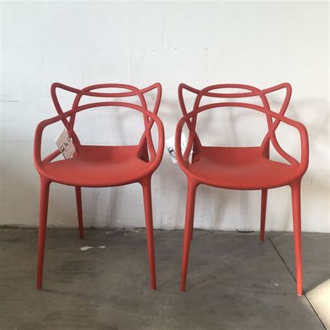 red chairs sitting      cement floored area  white wall