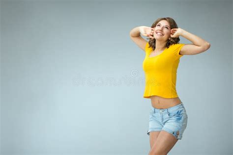 Image Of Happy Young Woman Wearing Yellow Shirt And Jeans Shorts Stock