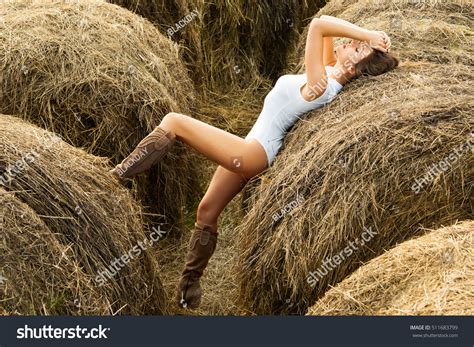 Sexy Woman In White Bodysuit Among The Haystacks In Warm Autumn Day