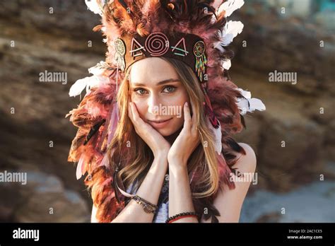 image of cute hippy girl in indian chief feather headdress walking by