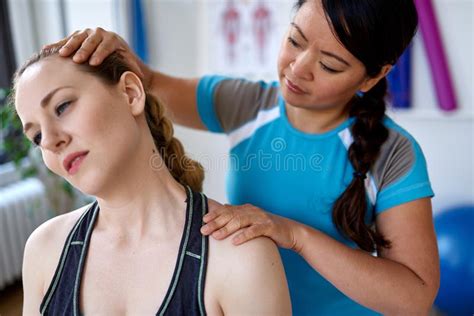 chinese woman massage therapist giving a treatment to an attractive