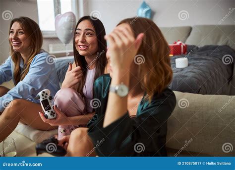 Smiling Dark Haired Woman Playing A Video Game With Her Guests Stock