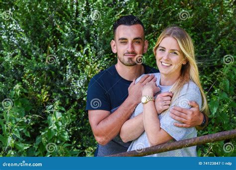 Man Hugging Smiling Blonde Girlfriend Behind Gate Stock Image Image