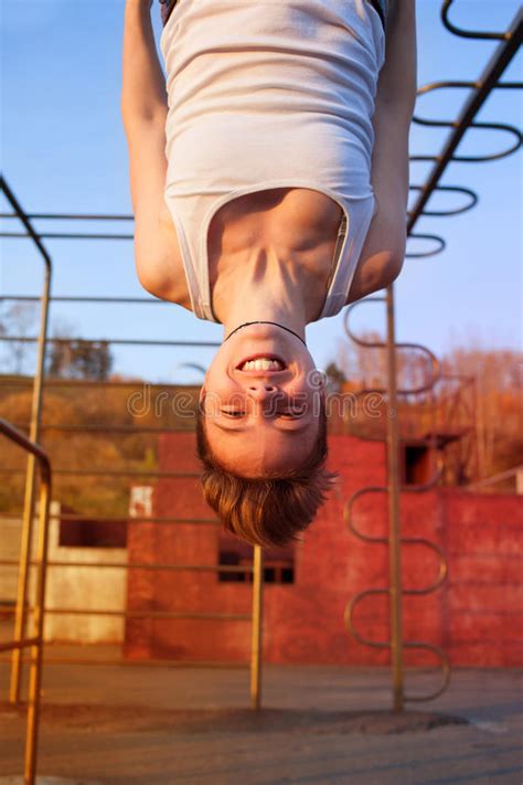 girl hanging upside down on gymnastics rings stock image