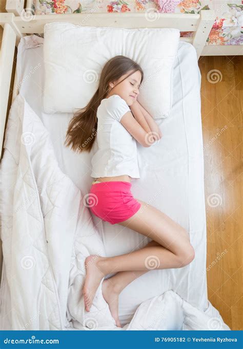 view from above on brunette teenage girls in pajamas sleeping on stock